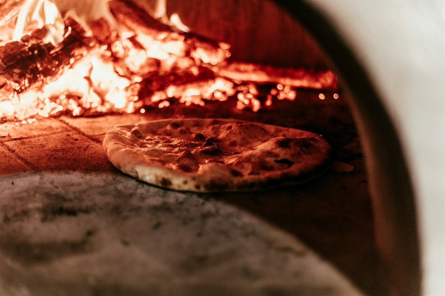 Une pizza devant les flammes d’un four